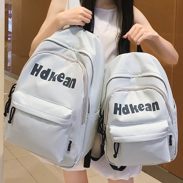 A new Korean-style ins high-appearment-level solid color simple letter backpack for couples, a casual, lightweight and large-capacity backpack full figure