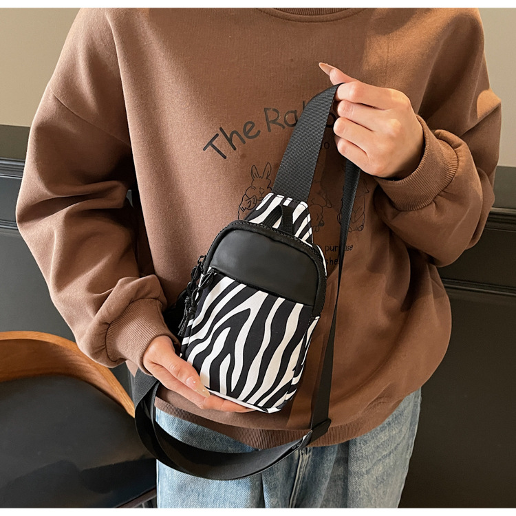 A new retro Japanese and Korean leopard print mini crossbody bag for women, with a high-end color contrast, is portable and sporty for commuting full figure