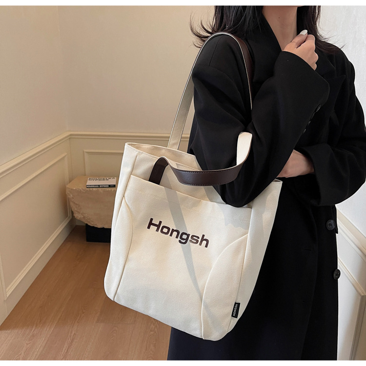2025 New stylish Korean-style solid color canvas handbag, high appearance level, simple single-shoulder bag, casual commuting tote bag full figure