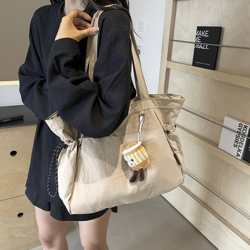 A minimalist tote bag from a trendy women's brand, with a niche design and a Harajuku style, a high-quality commuter single-shoulder bag, and a Maillard color handbag details Picture