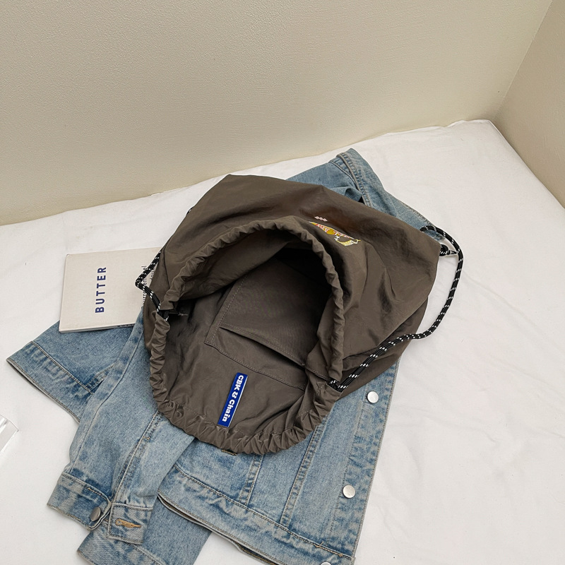 A new Japanese-style trendy fashion backpack, cute cartoon, eco-friendly, drawstring, large-capacity embroidered casual student bag Application Scenario