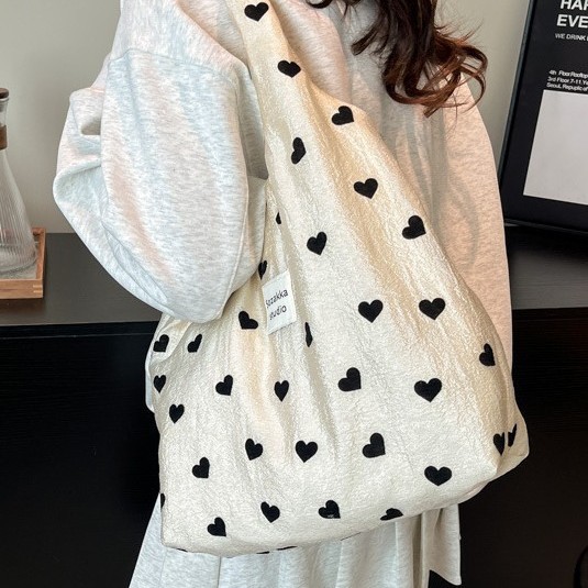 A new style of heart-shaped canvas single-shoulder bag for girls, a large-capacity handbag, a makeup bag and a student underarm bag details Picture