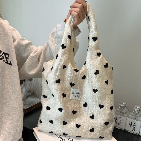 A new style of heart-shaped canvas single-shoulder bag for girls, a large-capacity handbag, a makeup bag and a student underarm bag full figure