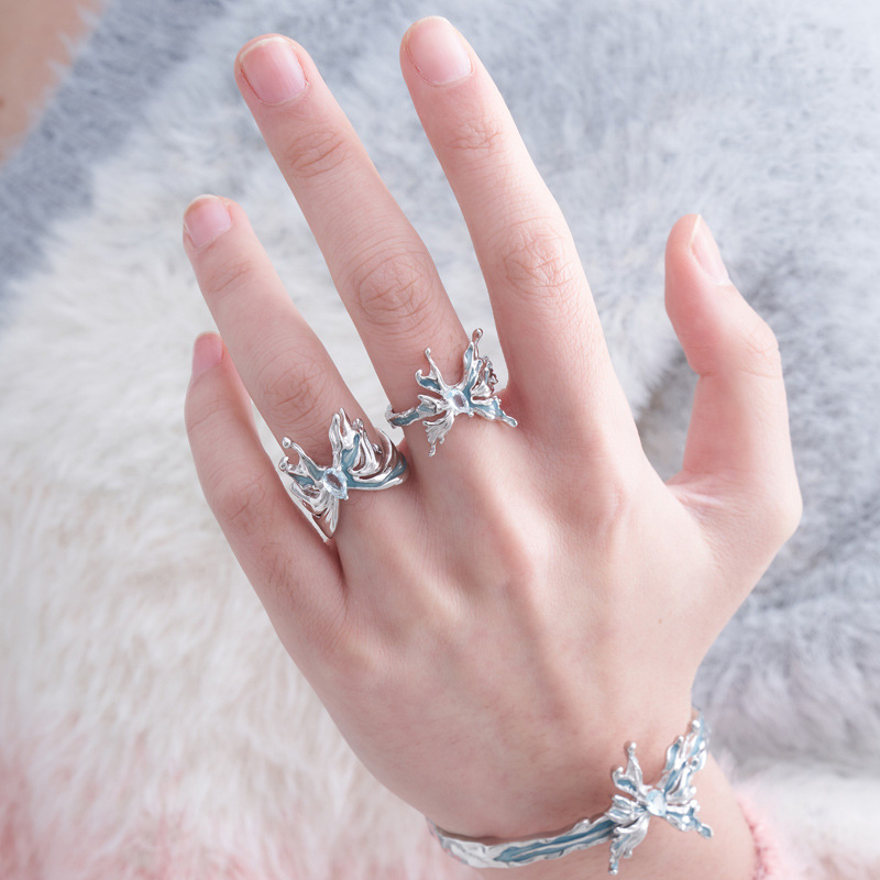 A niche design of an ice blue resin butterfly-shaped opening ring for women with an irregular texture on Instagram. A cold style food ring trend full figure