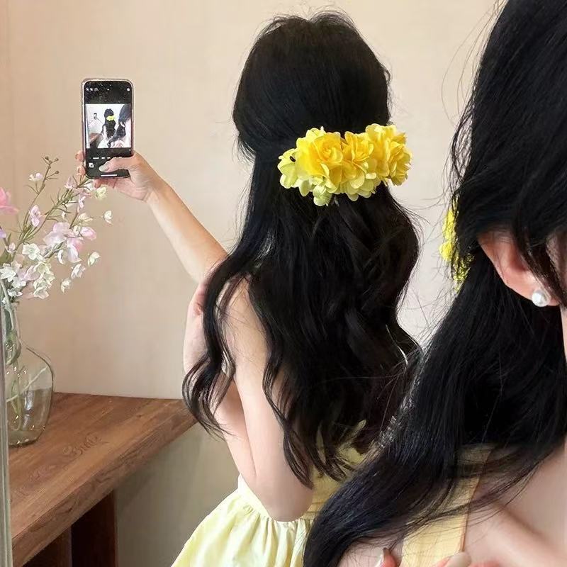 A huge banana clip in the shape of a mermaid by the seaside, a forest-themed flower grab clip, and a horizontal banana clip Application Scenario