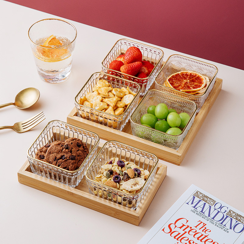 A glass compartments fruit plate for roasting tea around a stove, a modern living room snack plate, a home snack, candy, dried fruit and dim sum platter full figure