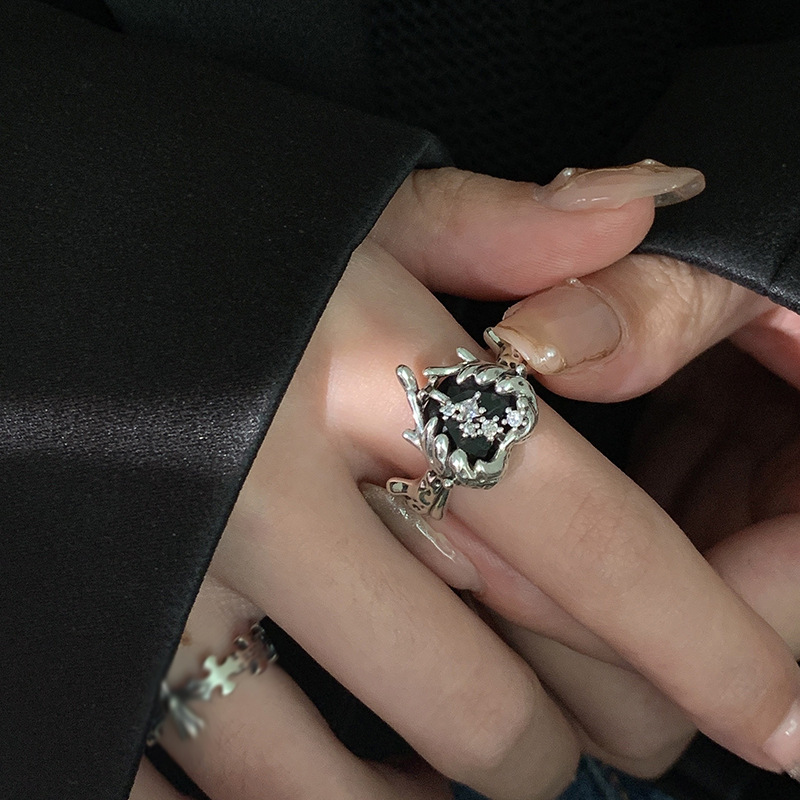 A black zircon ring with a cold and unique style for women on Instagram. It features a dark heart-shaped texture with an open design, which is a light luxury and niche design full figure