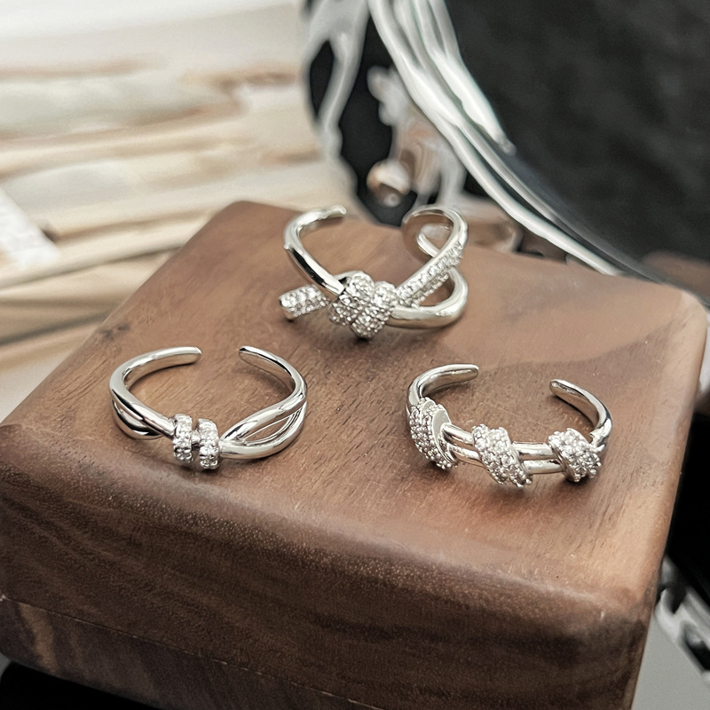 This is a fashionable and exquisite index finger ring with a unique design sense, slightly inlaid lines, and a simple opening. It features a crossed knot and a cold style Specification drawing