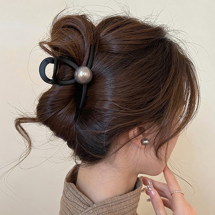 A new large black pearl scratch-clip for women, featuring a simple, niche and high-end look. The shark clip on the back of the head is a retro hair accessory Application Scenario