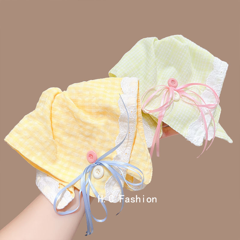A Korean girl's large yellow checkered button bow square scarf large intestine circle shows off her face. She has a small ponytail hair band details Picture