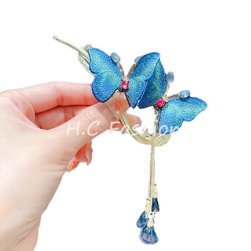 The new Chinese-style embroidered butterfly tassel hair clip exudes a retro feminine charm. It features a twisted one-line clip and a bun bun at the back of the head Item Picture