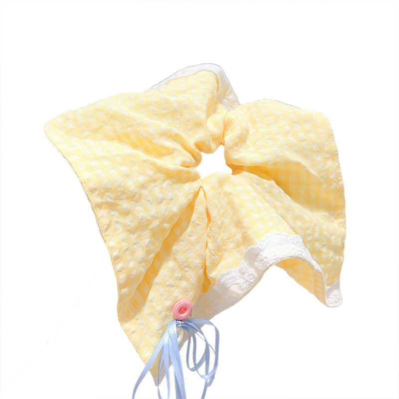 A Korean girl's large yellow checkered button bow square scarf large intestine circle shows off her face. She has a small ponytail hair band Item Picture