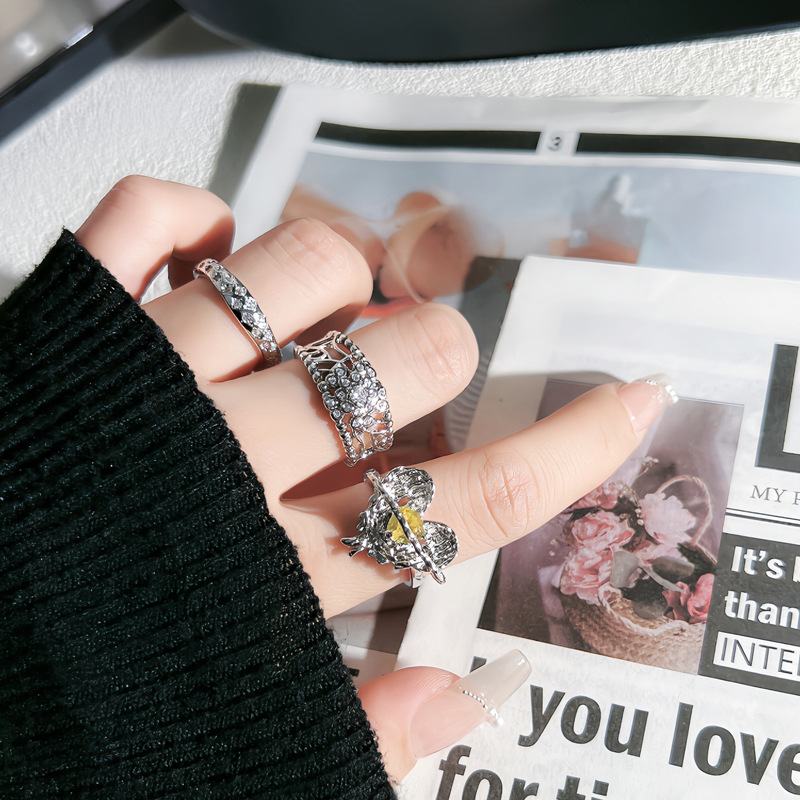 This is a stylish, hollowed-out, slightly inlaid open ring with a sweet and cool feminine touch. It is a delicate ring surrounded by a pleated heart with yellow diamonds details Picture