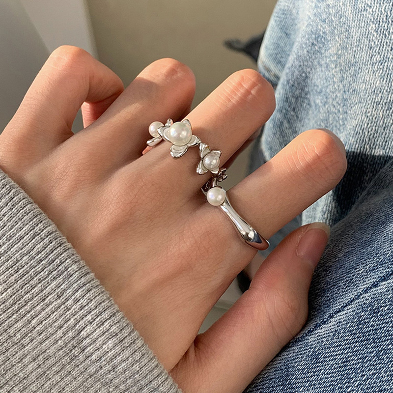 A Korean version of a niche design pearl butterfly ring with a cold and elegant feminine style, exuding a sense of luxury and sophistication. It is a high-end index finger ring full figure