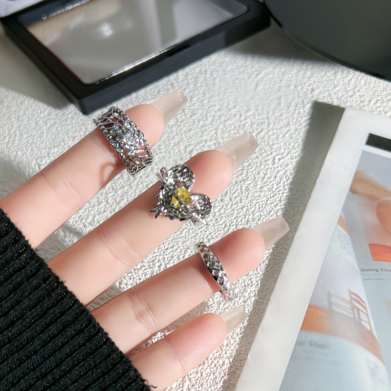 This is a stylish, hollowed-out, slightly inlaid open ring with a sweet and cool feminine touch. It is a delicate ring surrounded by a pleated heart with yellow diamonds full figure