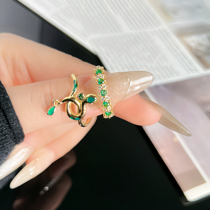 The snake-shaped opening ring for women in the zodiac year is a fashionable, light luxury and versatile index finger ring with a green diamond. It is a trendy accessory details Picture