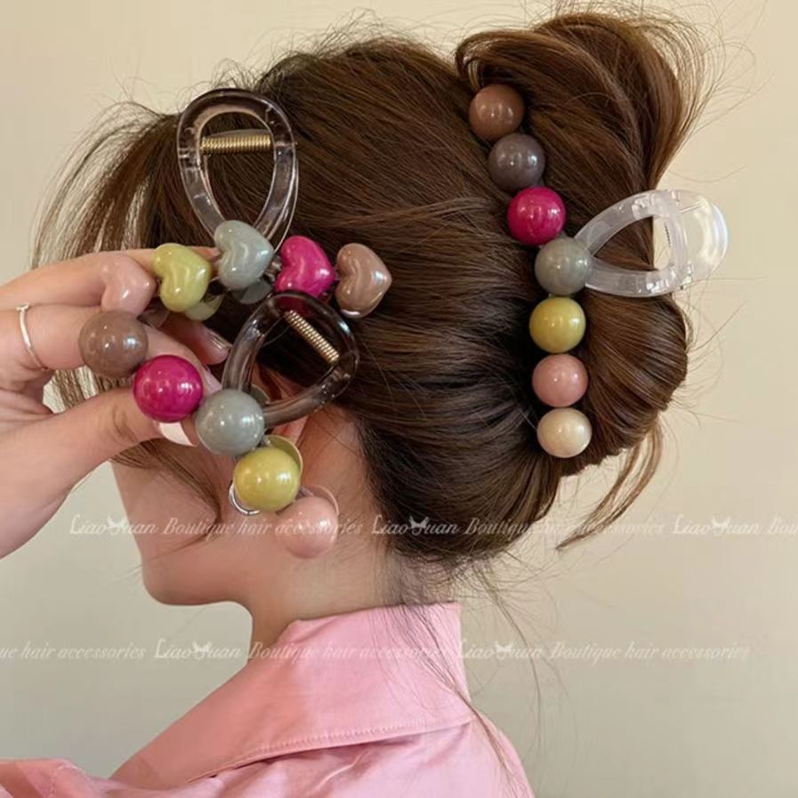 The new rainbow claw clip for summer 2024, a simple candy medium-sized hairpin at the back of the head, with a stylish updo and a shark clip full figure