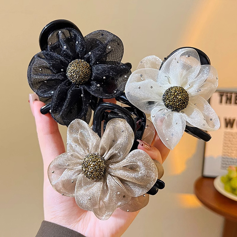 A fashionable and simple women's updo with a netted diamond sunflower clip, a shark clip at the back of the head, and a high-end flower hair clip details Picture