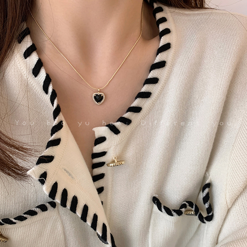 A light luxury black heart-shaped necklace with a French retro, niche and elegant design for women, paired with a collarbone chain accessory full figure