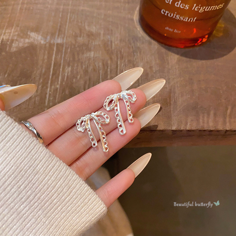 Hollowed-out ribbon bow earrings for women, with a light luxury, niche and high-end feel, versatile and elegant. Tassel ear studs are best-selling earrings full figure