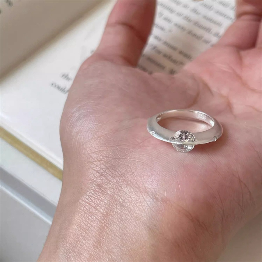 A rare and unique female design of a rotating zircon planet ring with a sparkling diamond opening full figure