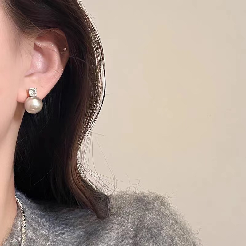 A single zirconia in a cold silver-gray color is so numerous. The grey pearl stud earrings are a niche, light luxury, and high-end design accessory for women details Picture
