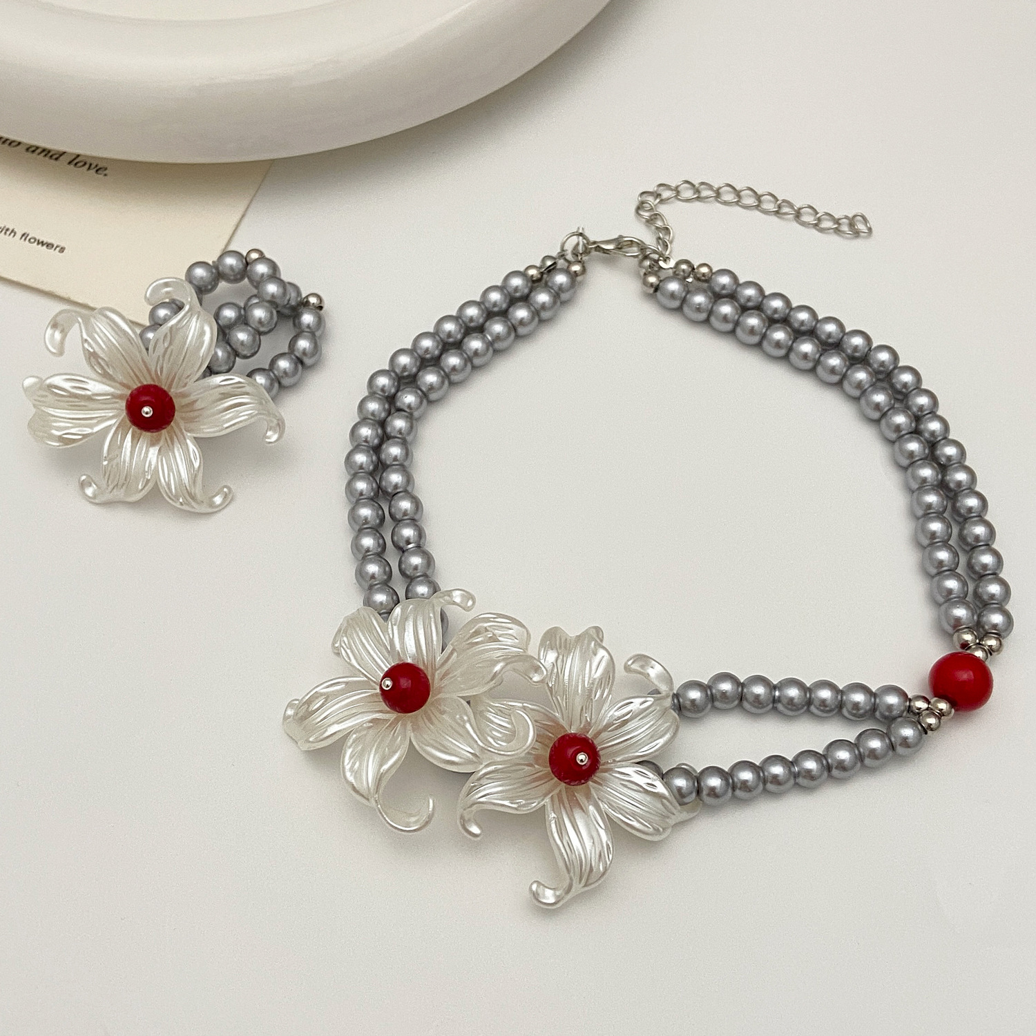 A unique design of iris flower silver pearl necklace with floral embellishments on the neck, a men's same style and a women's choker collarbone chain ring Application Scenario