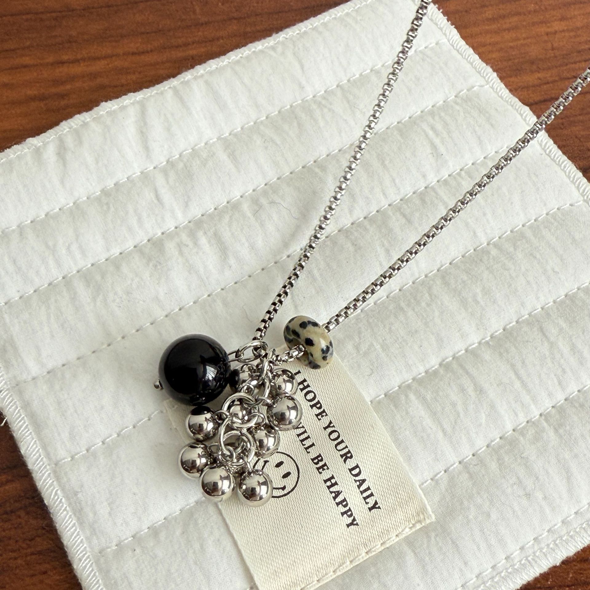 This is a versatile sweater chain with a tiger's eye titanium steel grape string and round ball design, which is the same style as a niche blogger. It's an ins fashion necklace details Picture