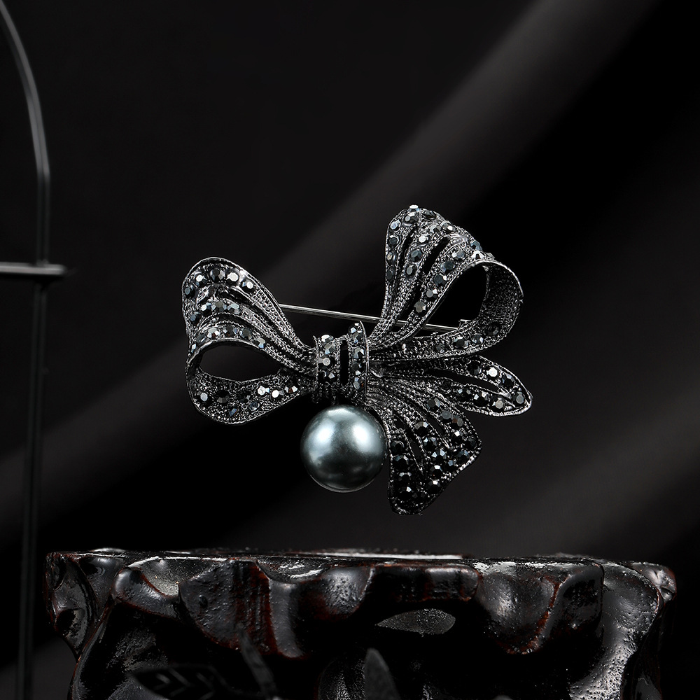Korean-style black diamond-encrusted bow pearl brooch for women, creative design sense, fashionable suit jacket cardigan pin full figure