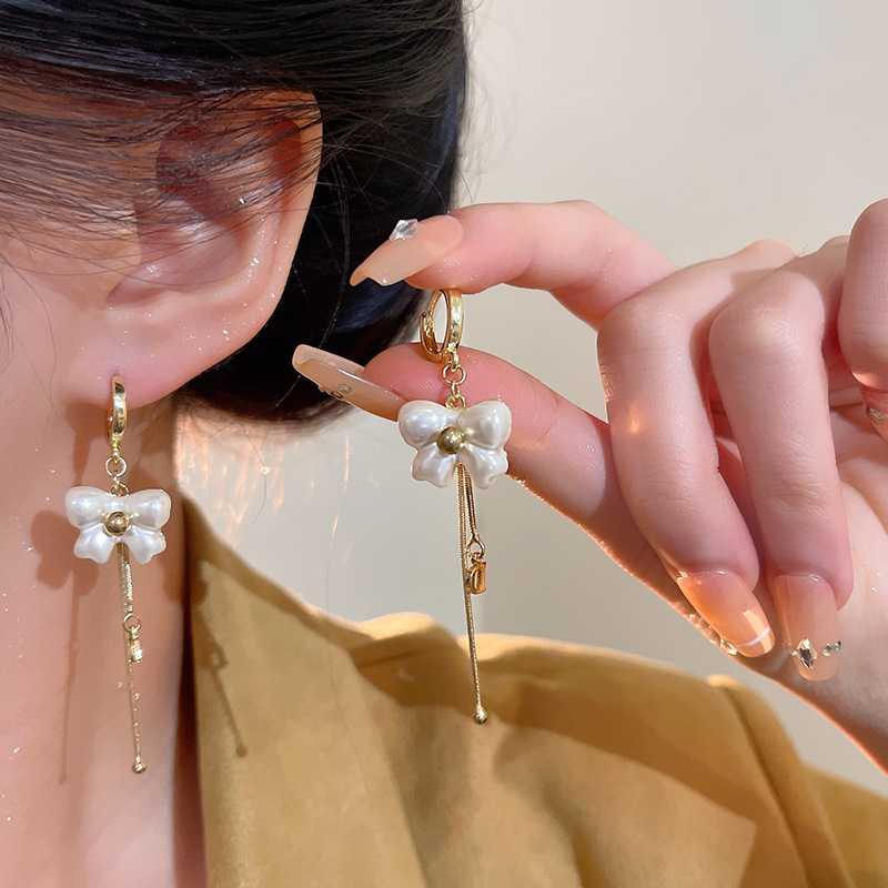 The white bow earrings with an ethereal charm exude a light luxury vibe for women. The long stud earrings have a design sense and are the same as the popular earrings on the Internet details Picture