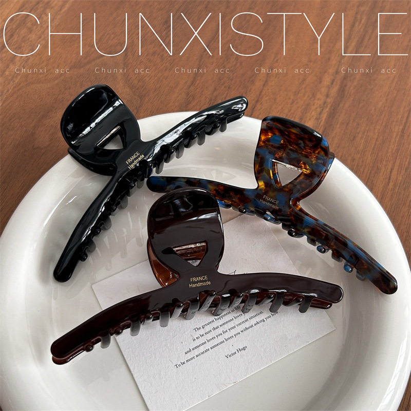 The large-sized acetate hair clip has a lot of volume and a retro style. It's a 13cm large-sized shark clip at the back of a woman's head Specification drawing