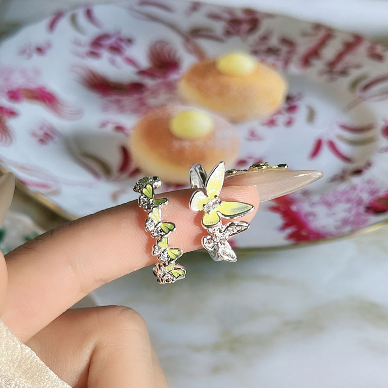 A fresh and unique summer street style with a yellow drip glaze butterfly, exuding a sense of fashion and sophistication. The open ring is exquisitely layered and worn by a woman details Picture
