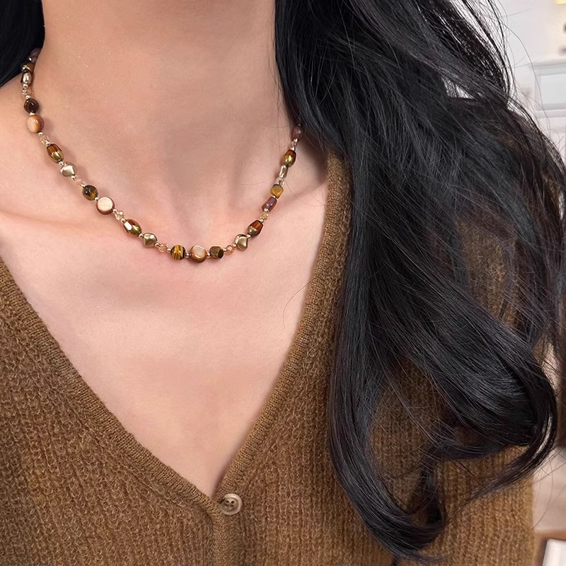Maillard's light luxury and niche coffee-colored pearl necklace with a beaded feel and tiger's eye stone is a versatile collarbone necklace for women. Wholesale full figure