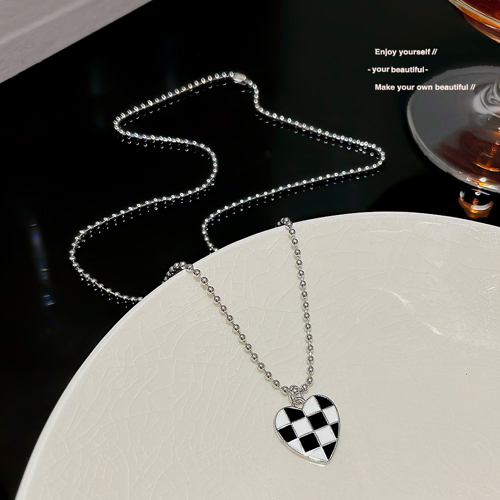 Stainless steel necklace with a high-end female feel, black and white heart-shaped chessboard pendant, light luxury, ins style collarbone chain, popular sweater chain full figure