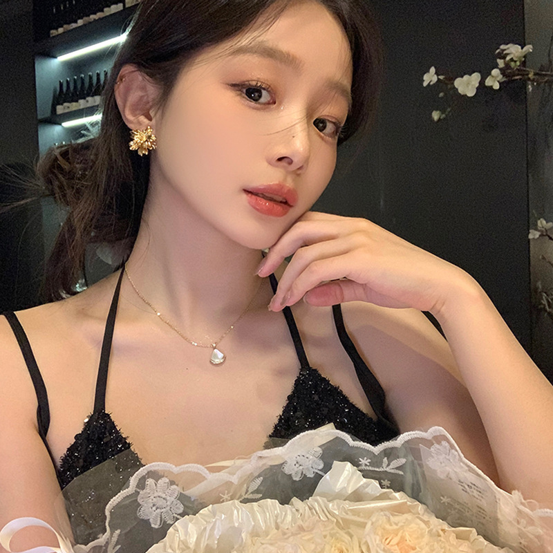 For autumn and winter, two women are wearing metal three-dimensional flower stud earrings with a light luxury and high-end feel. These golden earrings exude a unique charm and are popular online earrings details Picture