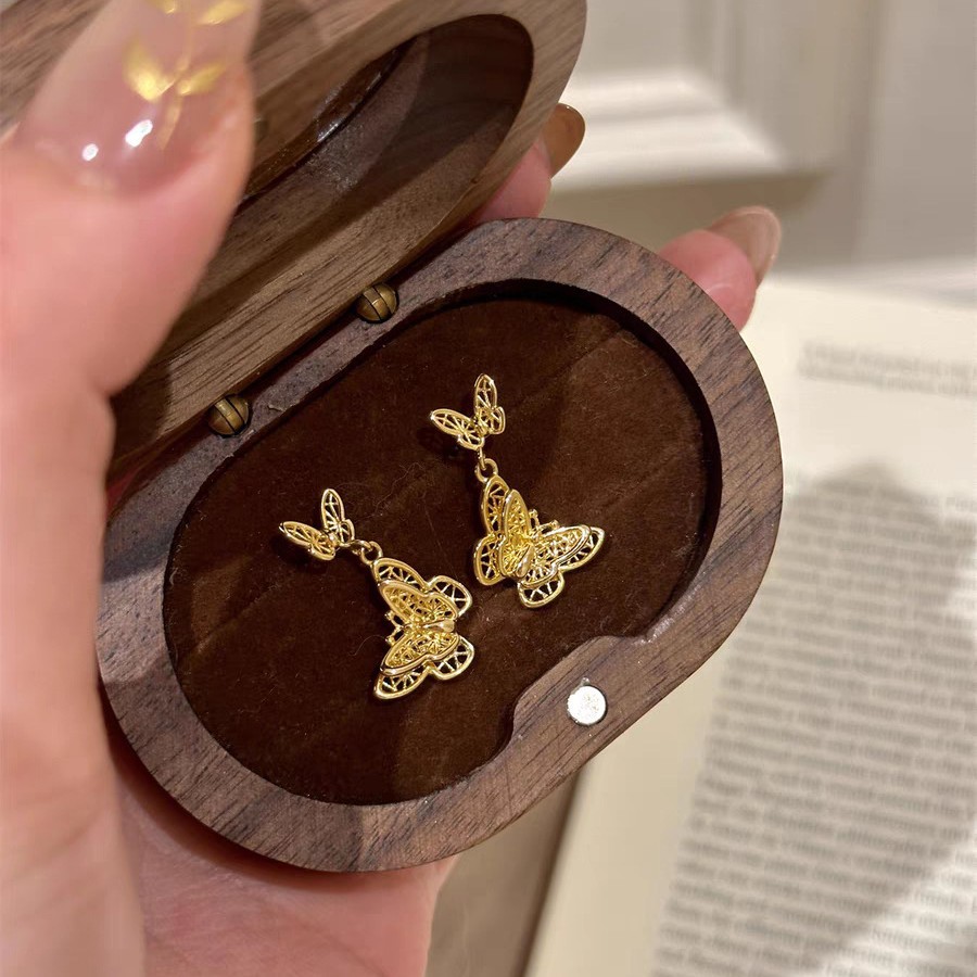 Golden filigree woven butterfly stud earrings for women, with a light luxury and niche design sense, a cool and elegant new Chinese-style earring accessory full figure