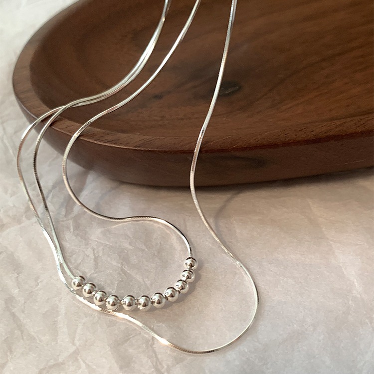 This simple double-layer round bead metal necklace exudes a unique, individualistic, fashionable and versatile charm. It features a collarbone chain design full figure