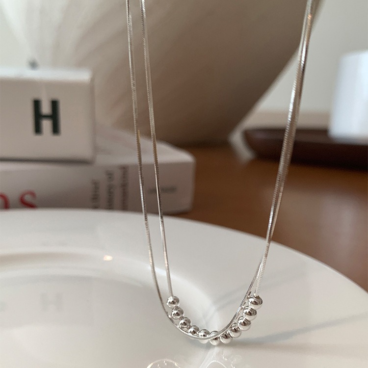 This simple double-layer round bead metal necklace exudes a unique, individualistic, fashionable and versatile charm. It features a collarbone chain design details Picture