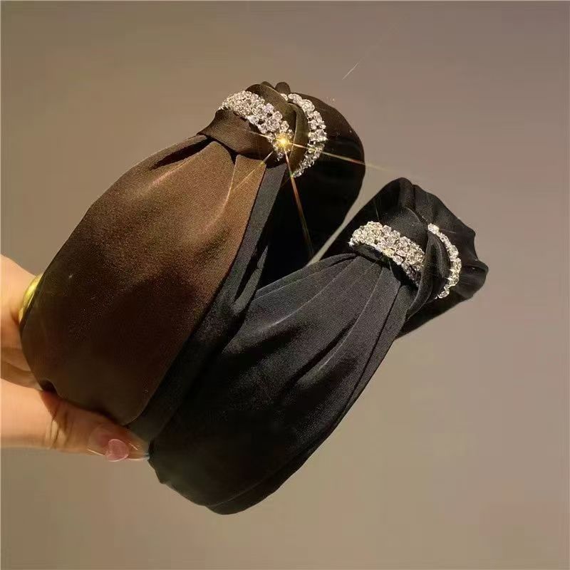 The small chanel-style Korean cross-rhinestone hairband exudes a high-end feminine charm. It features a double-layer fabric satin knot hairpin and a stylish headband details Picture