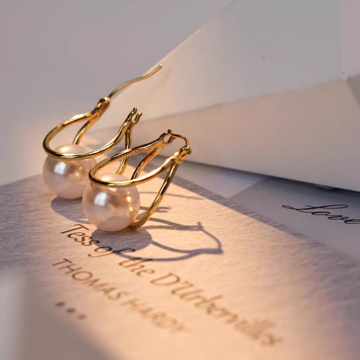 The retro Hong Kong-style double-loop pearl earring is a simple and cold style for women, fashionable and versatile. It is suitable for square faces and pairs well with overcoats as earrings full figure