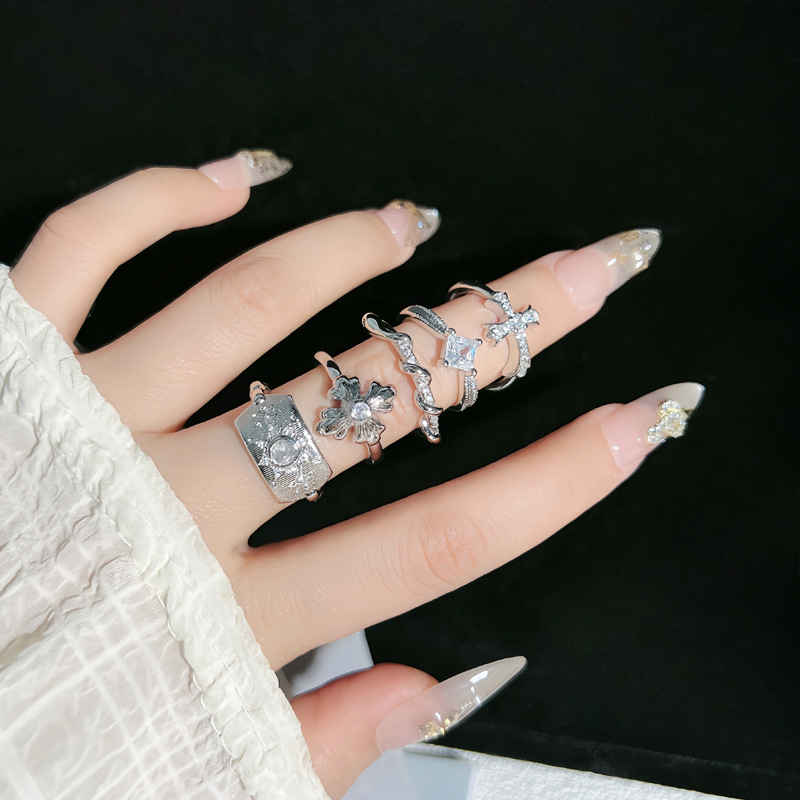 A simple and fashionable iris cross open ring with a cold and elegant style for women, exuding a sense of luxury and sophistication. It's a niche index finger ring full figure