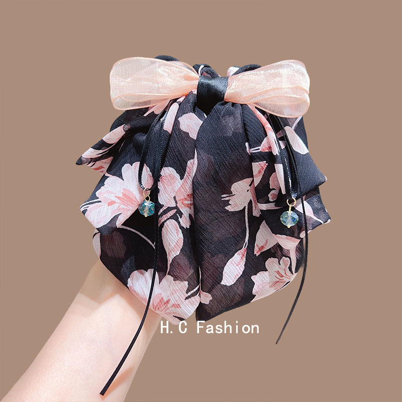 A new, elegant and sweet bow floral grabber with a gentle and refined style. It features a small ponytail at the back and a shark clip hair accessory full figure