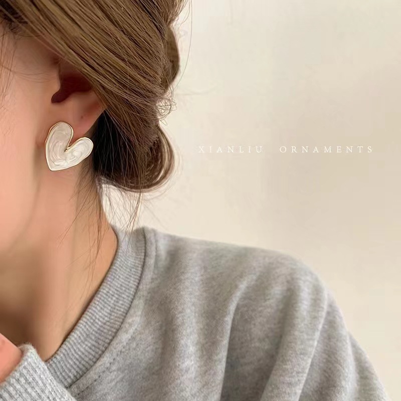 The 2025 new Japanese and Korean heart-shaped stud earrings are versatile, with a fresh and cold style and a high-end feel. They are a pair of pearlescent earrings for girls details Picture