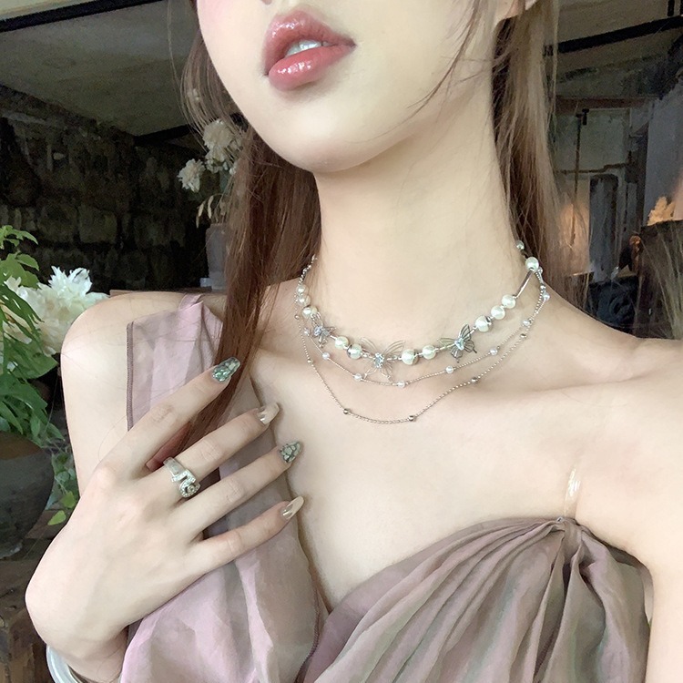 This trendy and cool tassel hollowed-out butterfly pearl necklace features a feminine and niche design. It is a fashionable and elegant collarbone chain accessory full figure