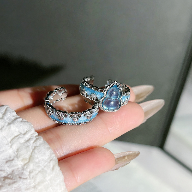 A simple and individual couple ring with a Chinese trend style, featuring a sea blue gradient enamel and a gourd-shaped opening. It has a lace trim Application Scenario