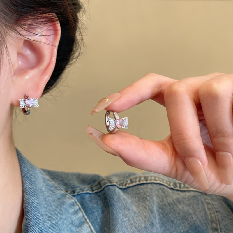 The diamond-encrusted pink heart-shaped bow ear buckles exude a feminine charm and a high-end design sense. The heart-shaped ear studs are light luxury and popular earrings on the Internet details Picture