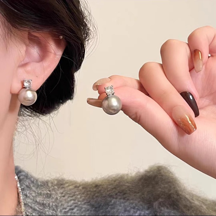 A single zirconia in a cold silver-gray color is so numerous. The grey pearl stud earrings are a niche, light luxury, and high-end design accessory for women full figure