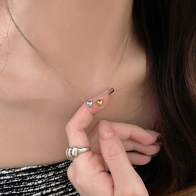 A small golden heart-shaped necklace for women with an ins style. It features a niche collarbone chain design that is simple and versatile, giving off a summer vibe full figure