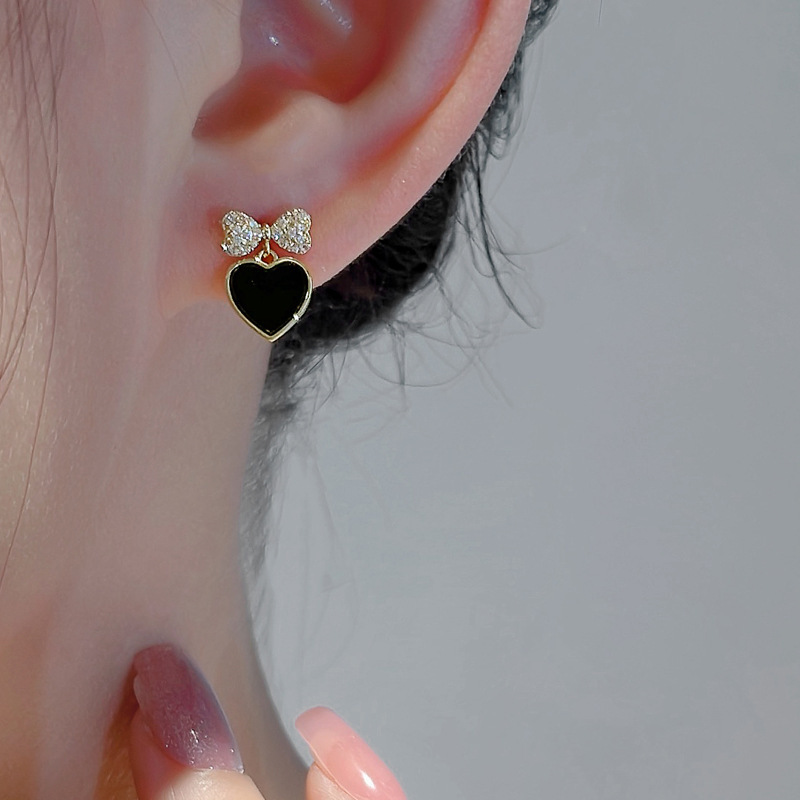 The new 925 silver needle black peach earrings are a favorite among women. The bow stud earrings feature a niche design and a cool style details Picture