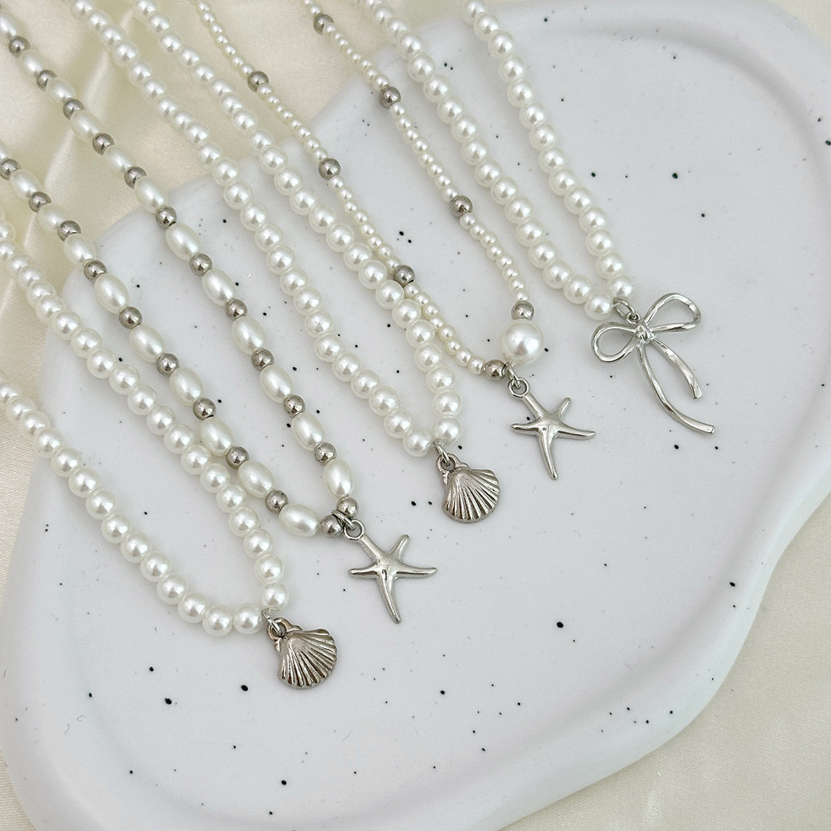 European and American cross-border jewelry, spicy girl style bow starfish pendant necklace, high-end imitation pearl beaded collarbone chain Application Scenario